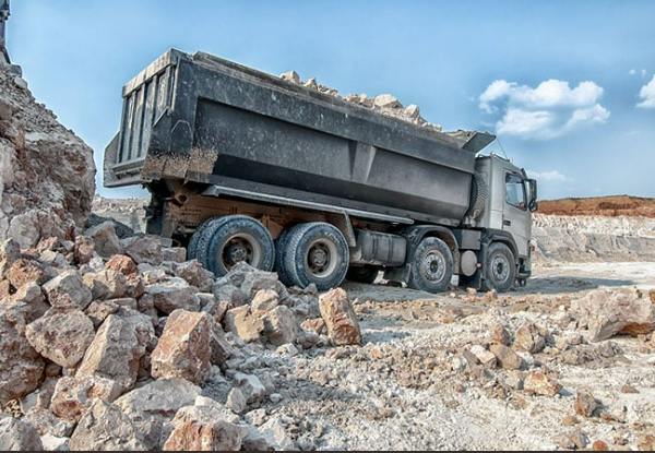 A dump truck is loaded with rocks in a quarry.