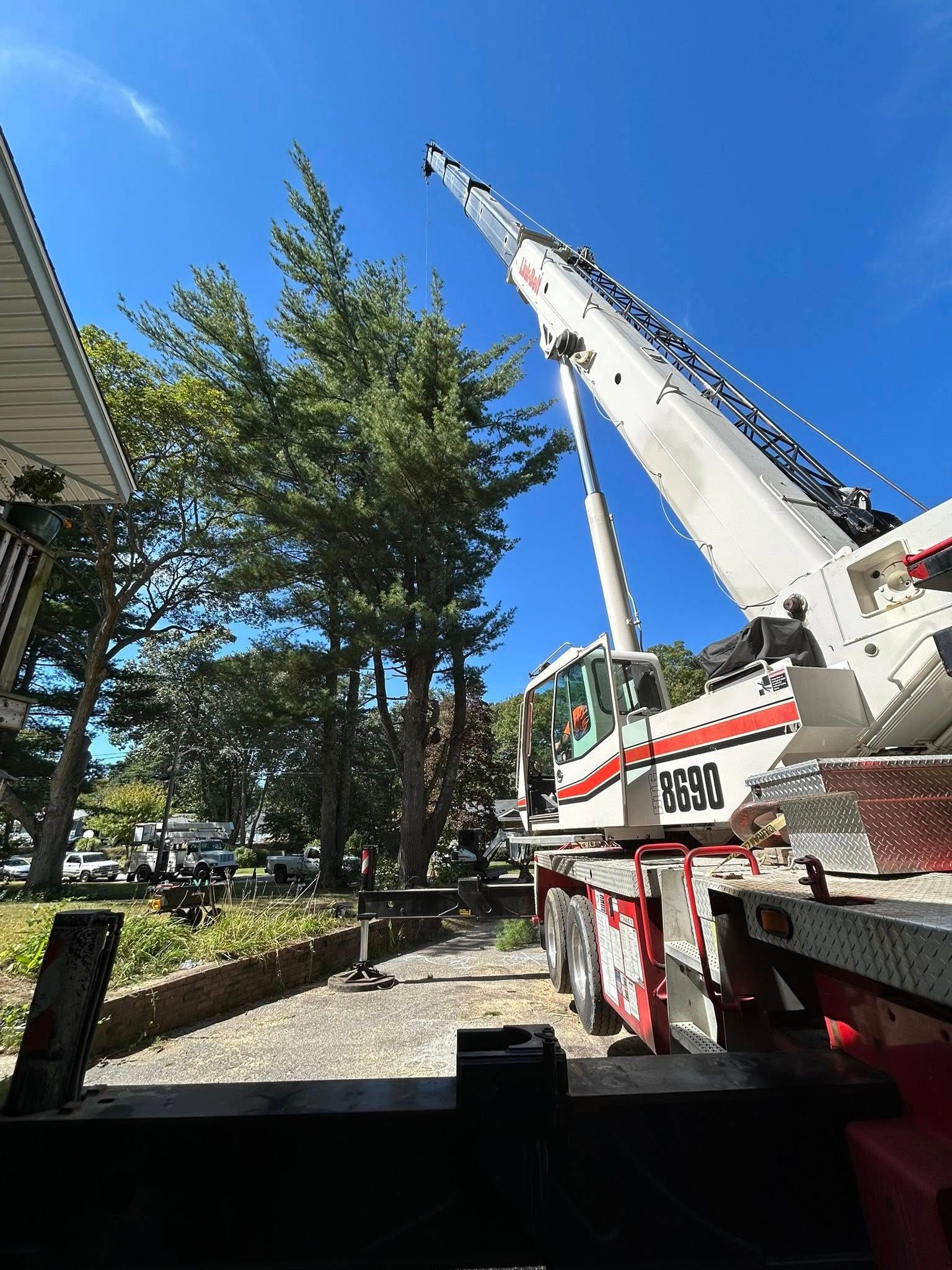 A large crane is sitting on top of a truck in front of a house.