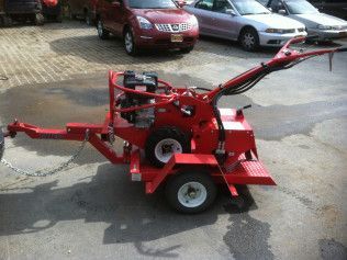 A red machine on a trailer is parked in a parking lot