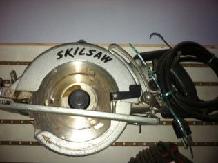 A skilsaw circular saw is hanging on a wall