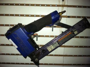 A blue stapler is sitting on a white wall