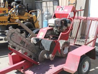A red trailer with a chainsaw attached to it