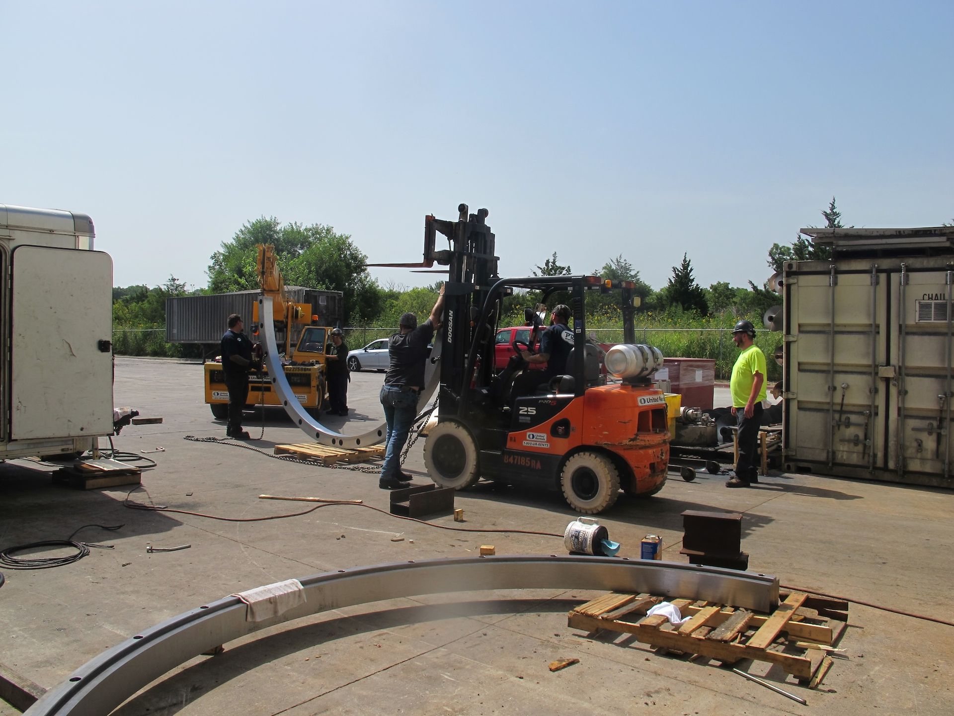 A forklift is being used to move a large piece of metal