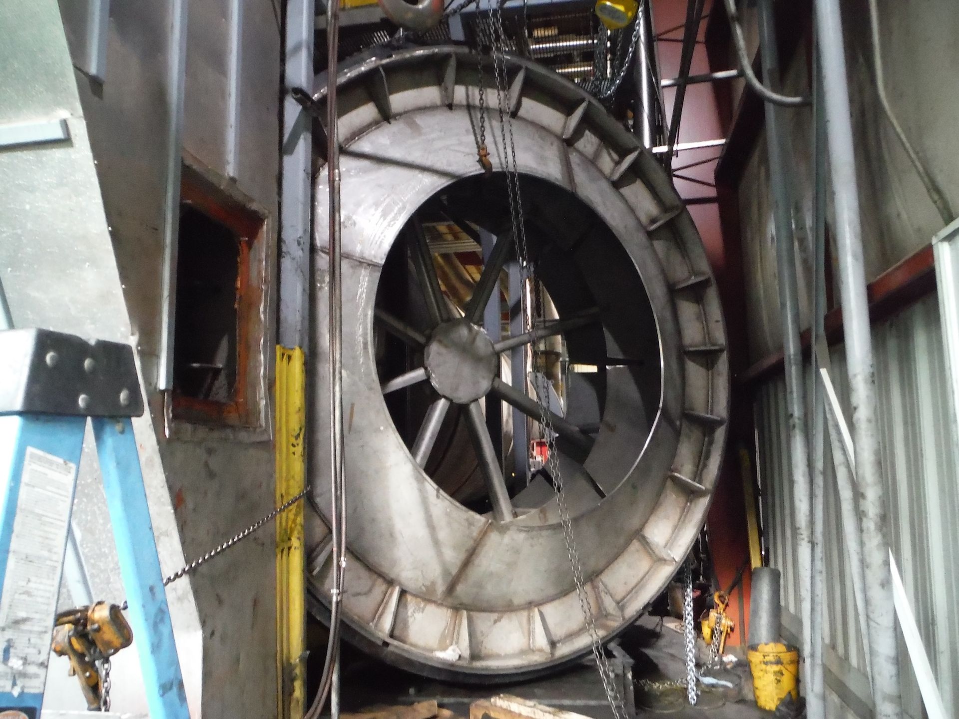 A large metal object is being lifted by chains