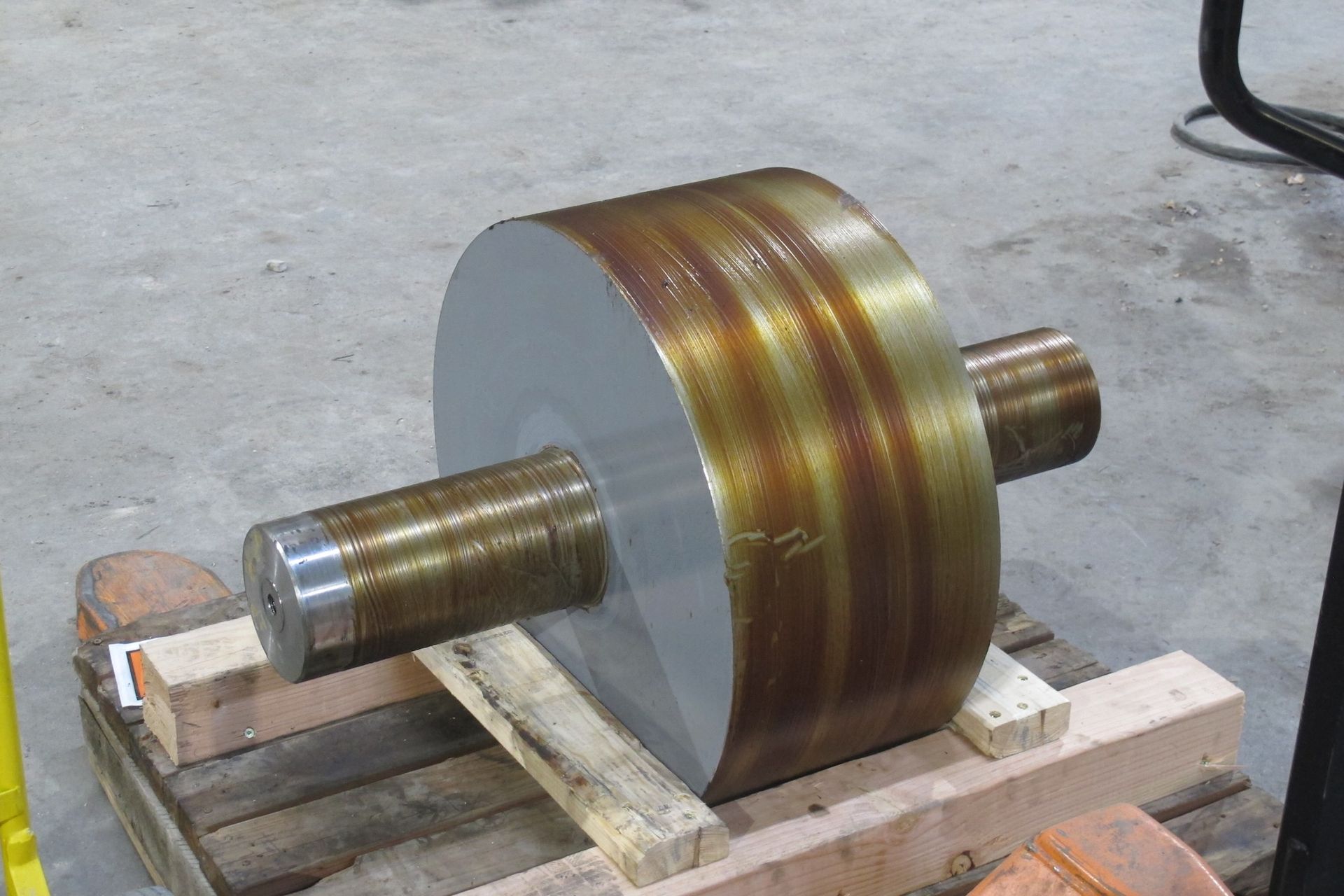 A large metal object is sitting on top of a wooden pallet.