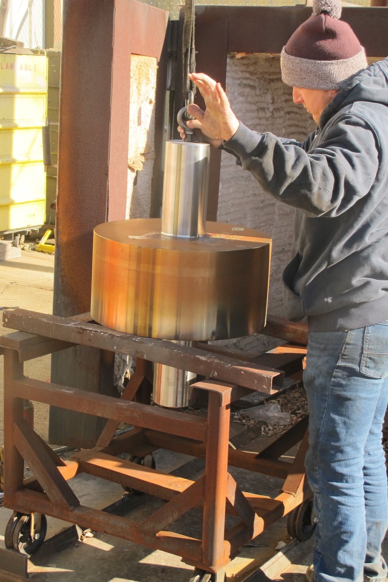 A man wearing a hat is working on a machine.