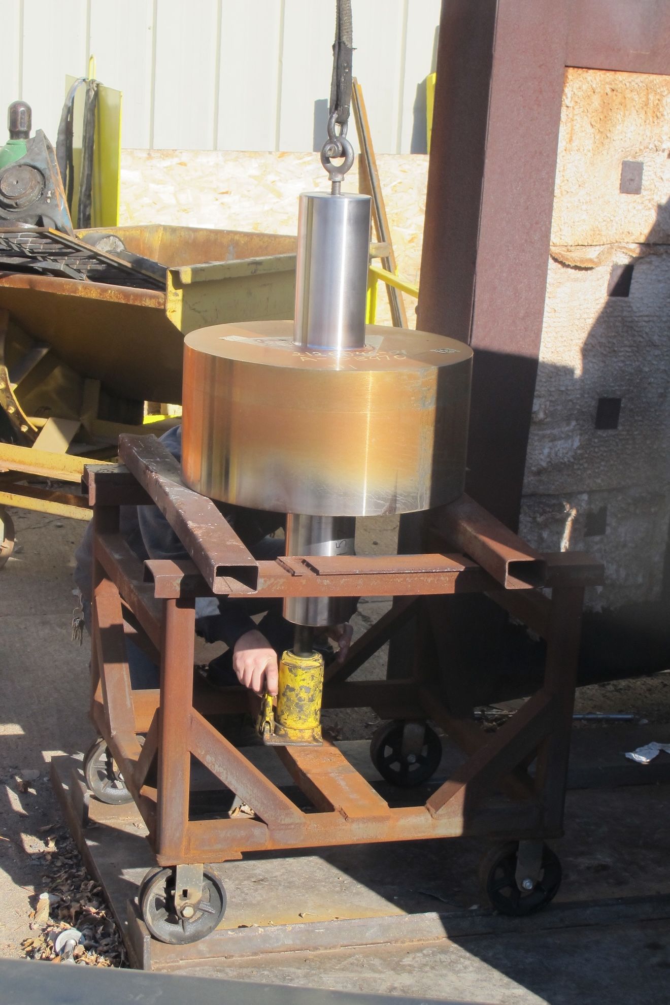 A large metal object is being lifted by a crane