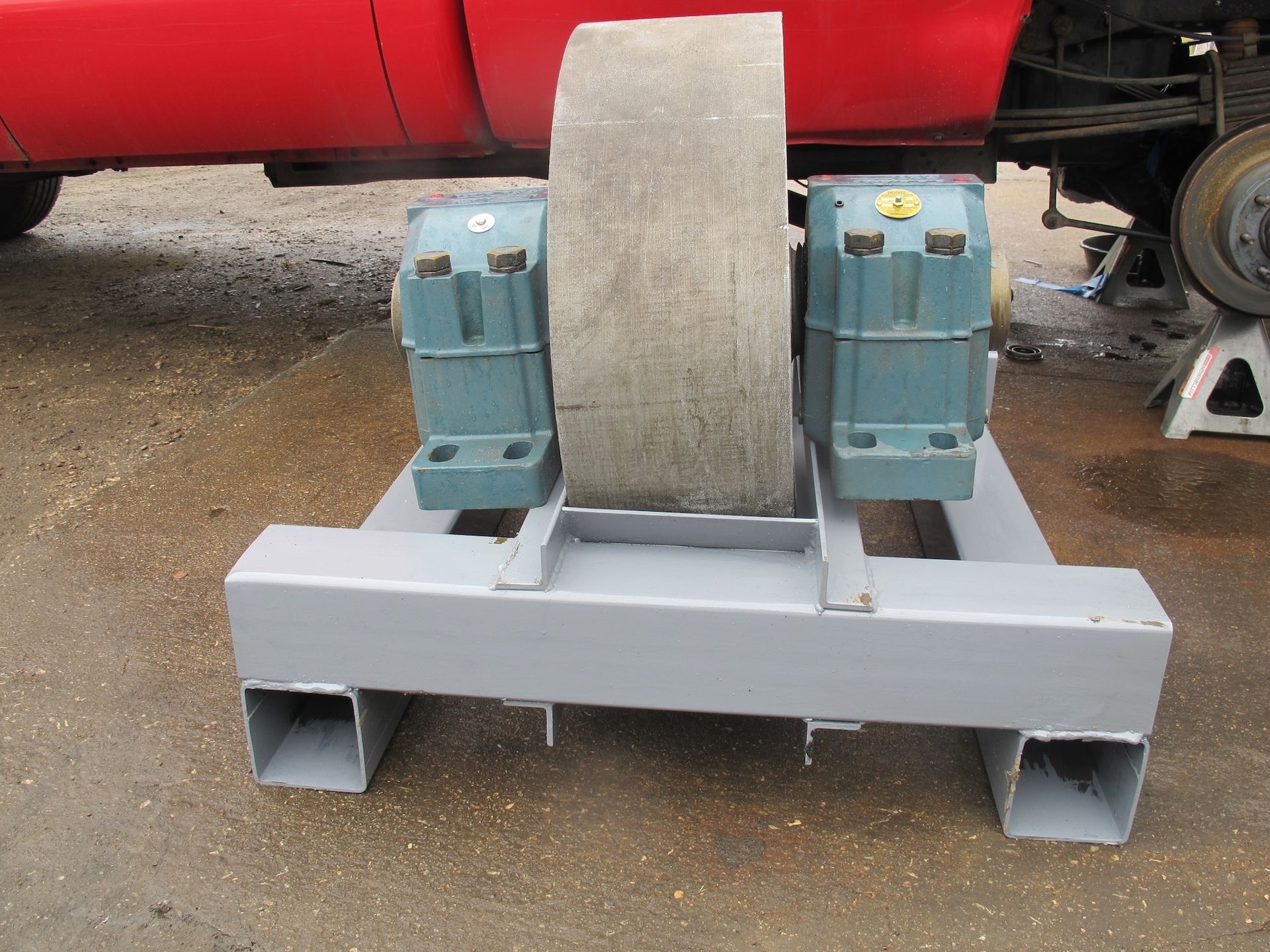 A red truck is parked next to a machine