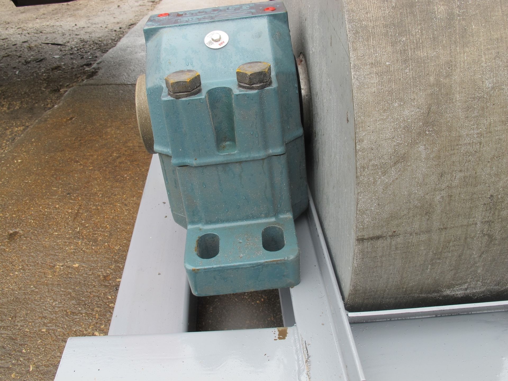 A blue machine is sitting on a concrete surface