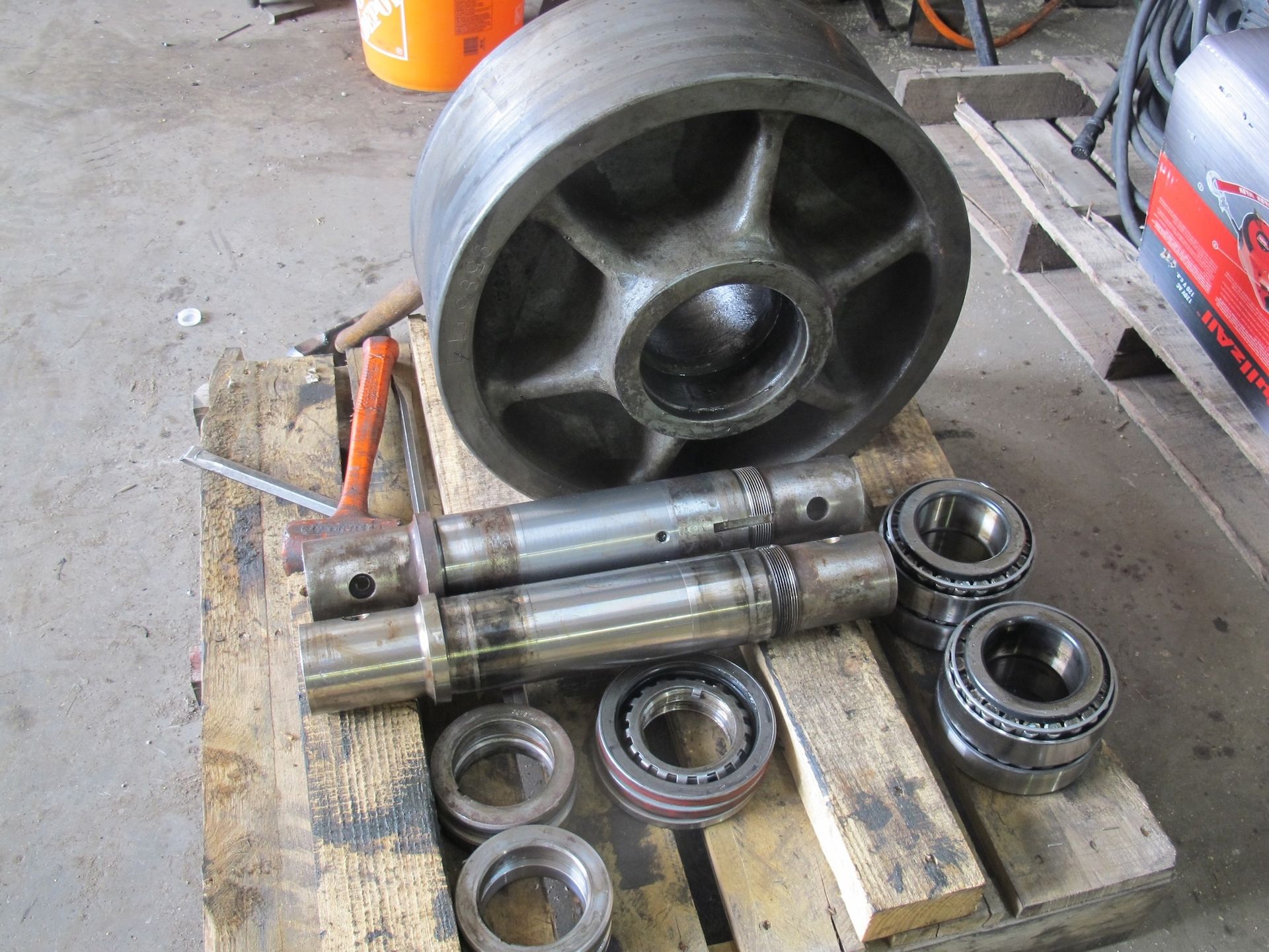 A wheel and bearings are sitting on a wooden pallet