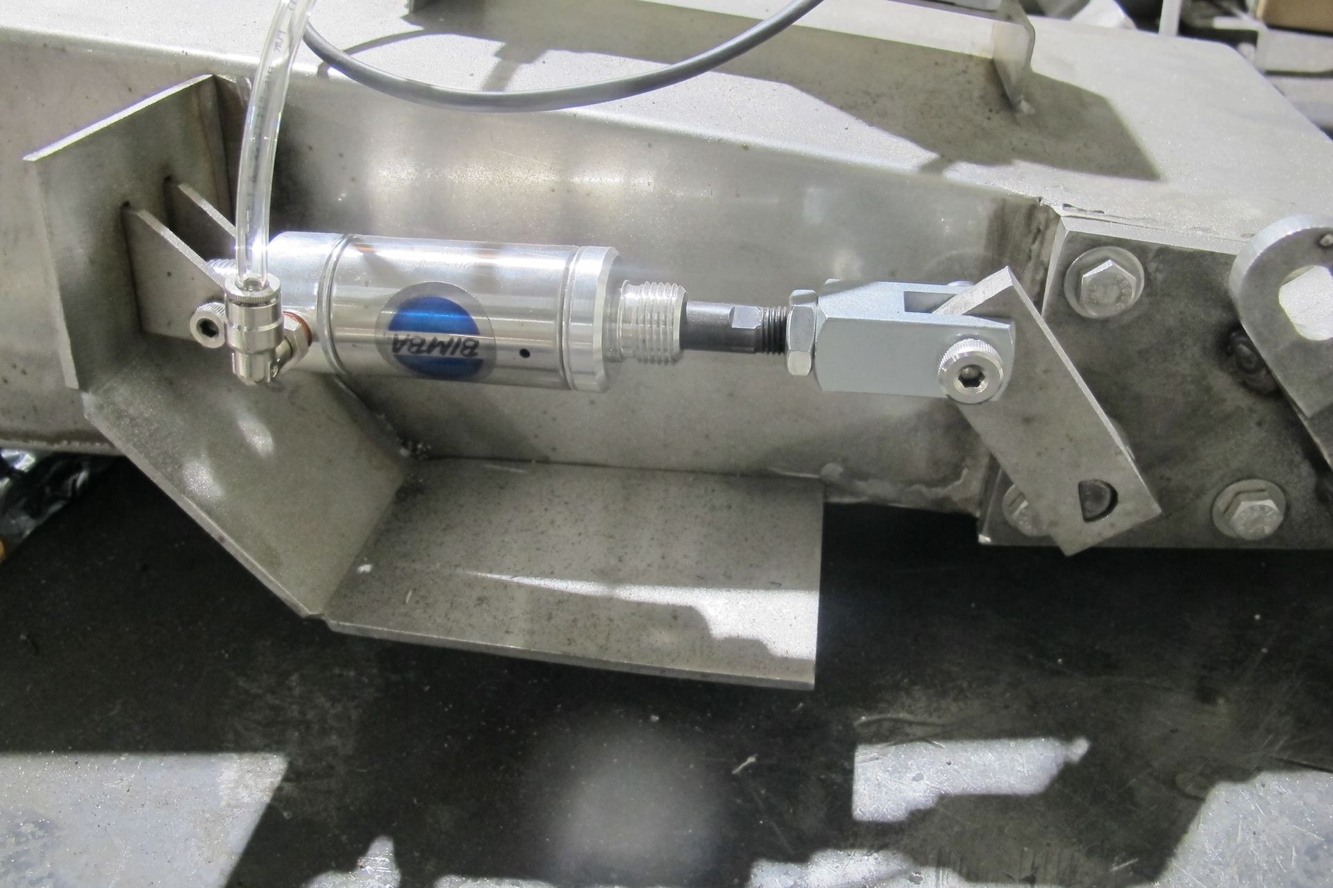 A close up of a stainless steel item with a hose attached to it