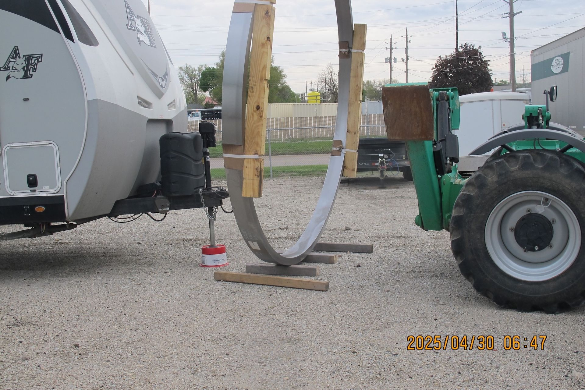 A trailer is being towed by a green tractor