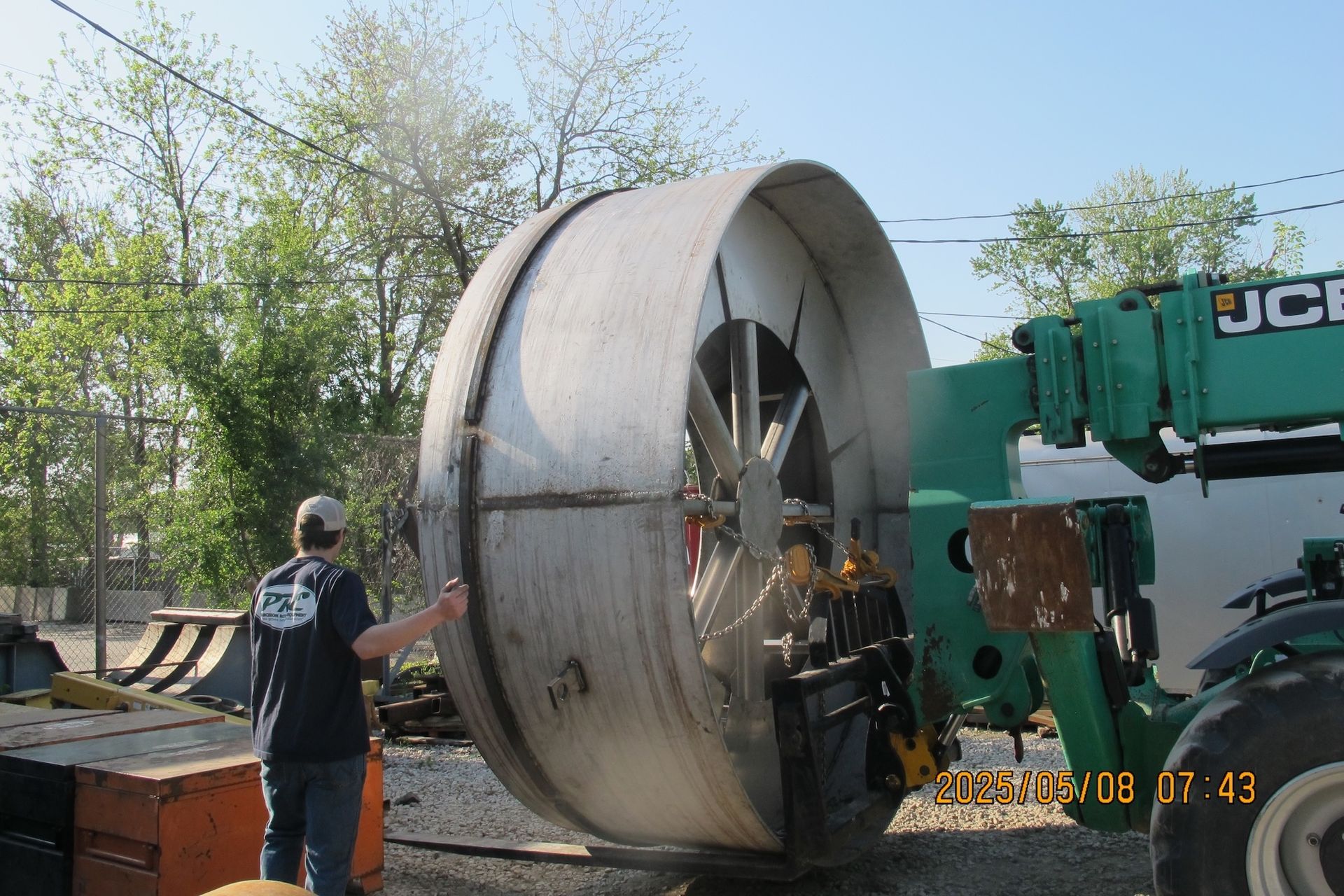 A man stands in front of a jcb crane