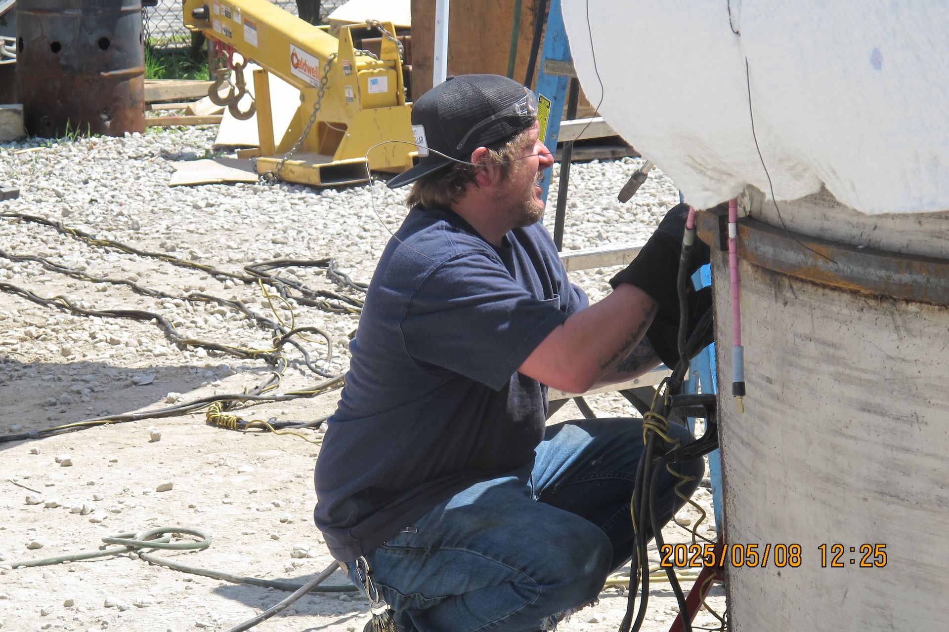 A man in a blue shirt is working on a pipe