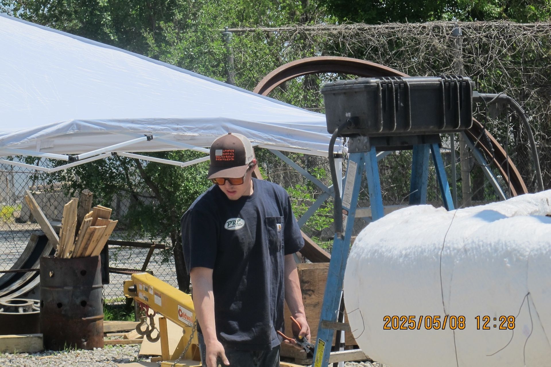 A man standing in front of a ladder with the time 12:37