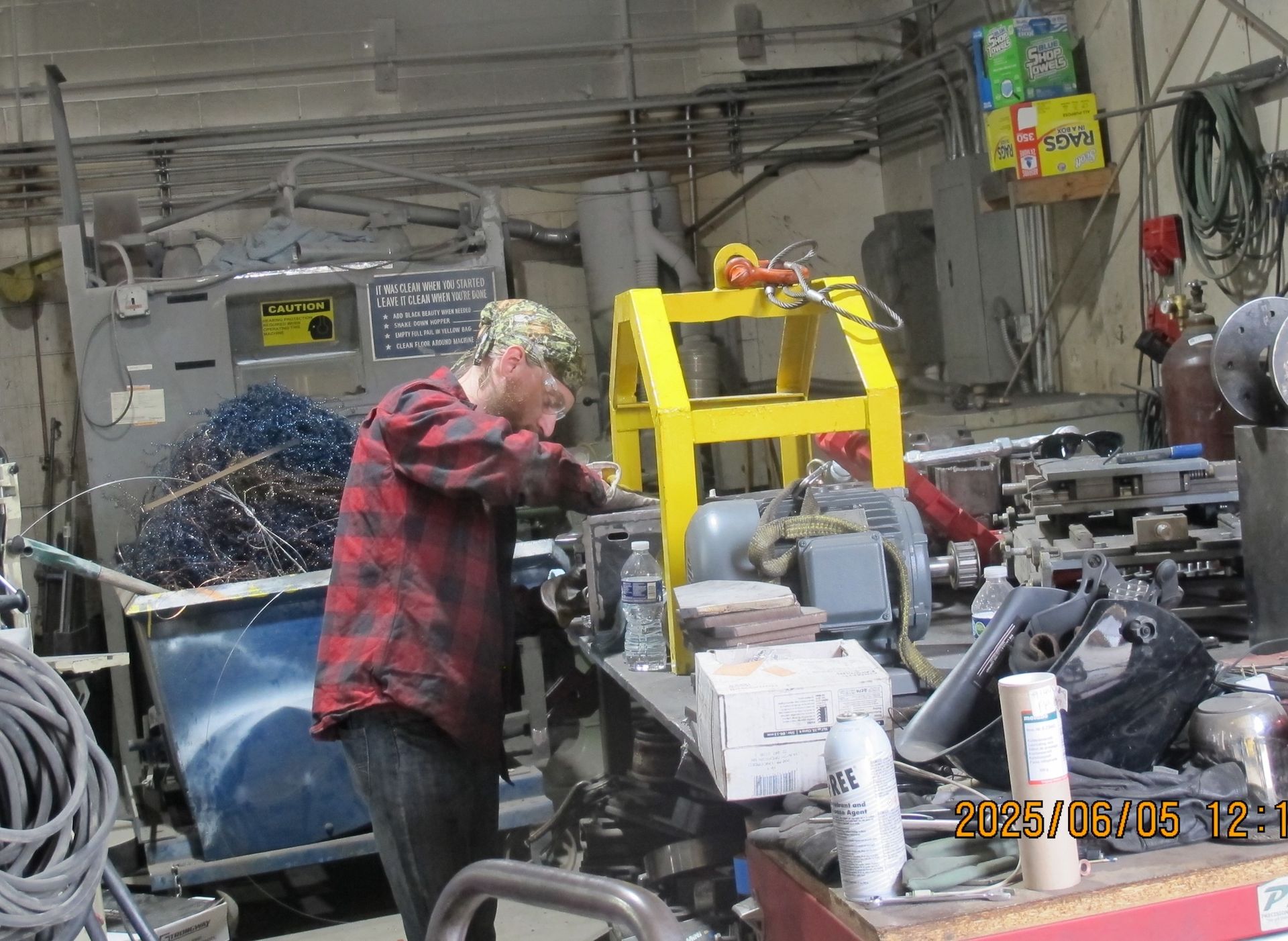 A man in a red plaid shirt is working on a machine