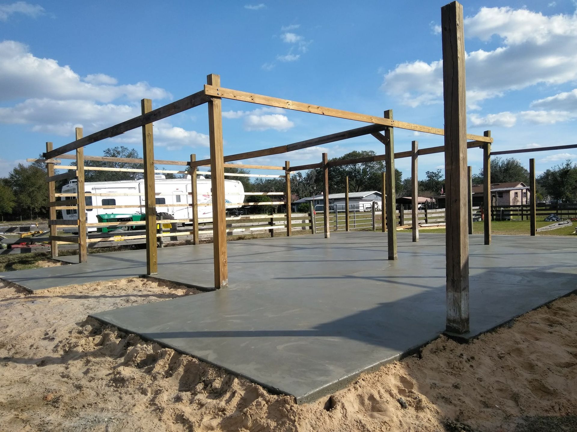 Concrete foundation with wooden support beams in an outdoor setting.