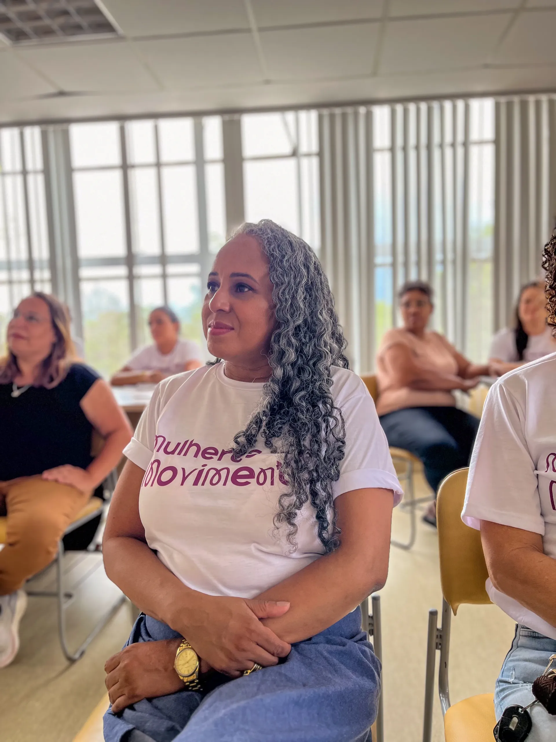 Uma mulher com tranças grisalhas vestindo uma camiseta