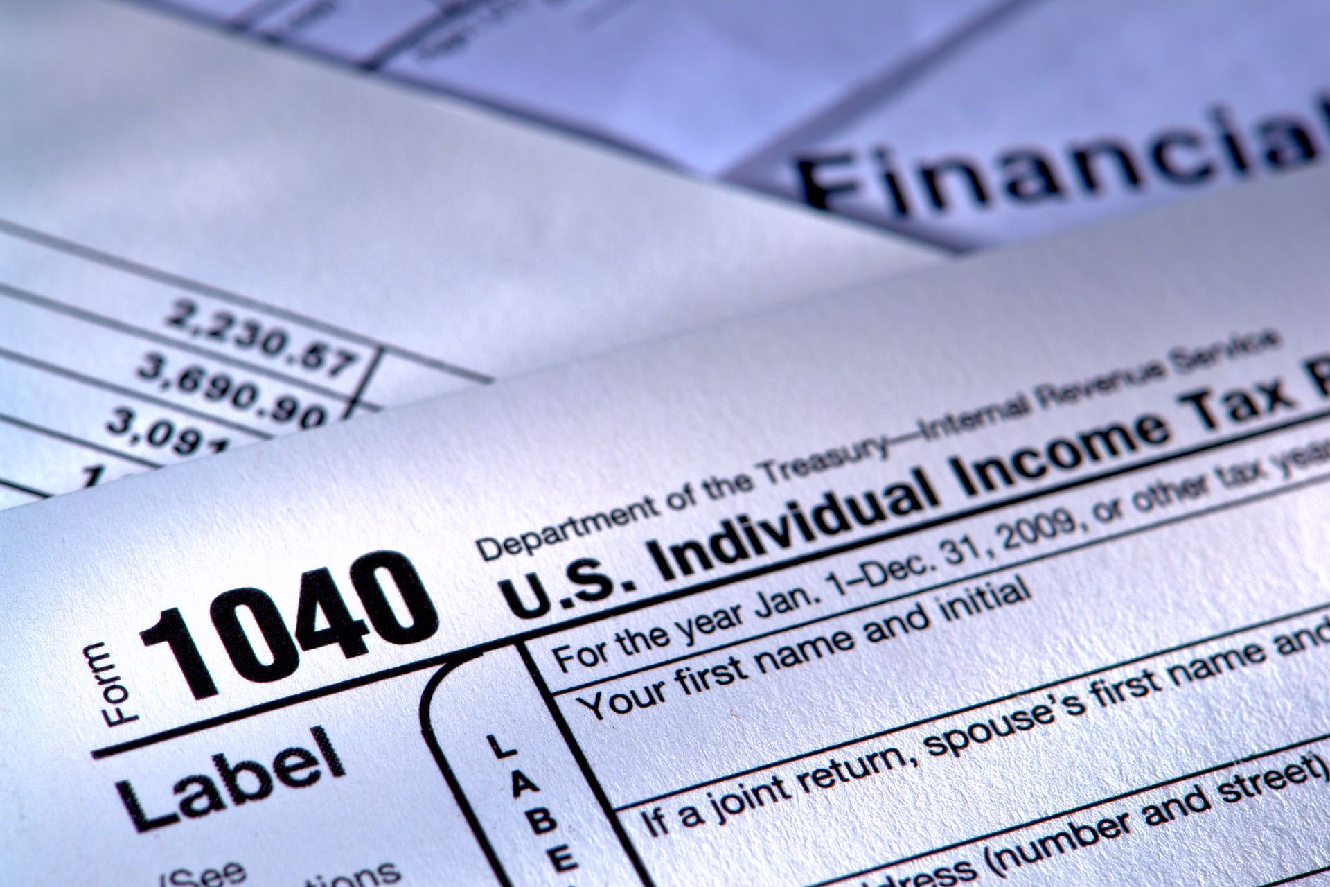 Close-up of IRS Form 1040 tax return paperwork with financial figures in the background