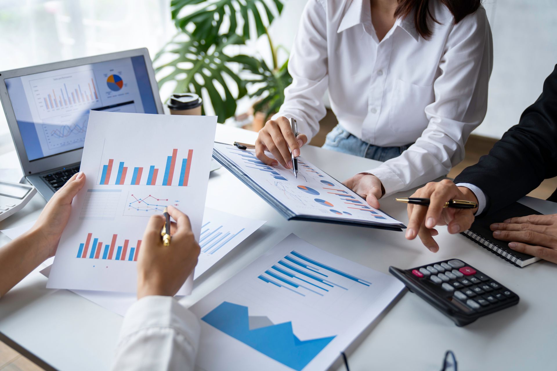 People reviewing charts and graphs on documents during a business meeting
