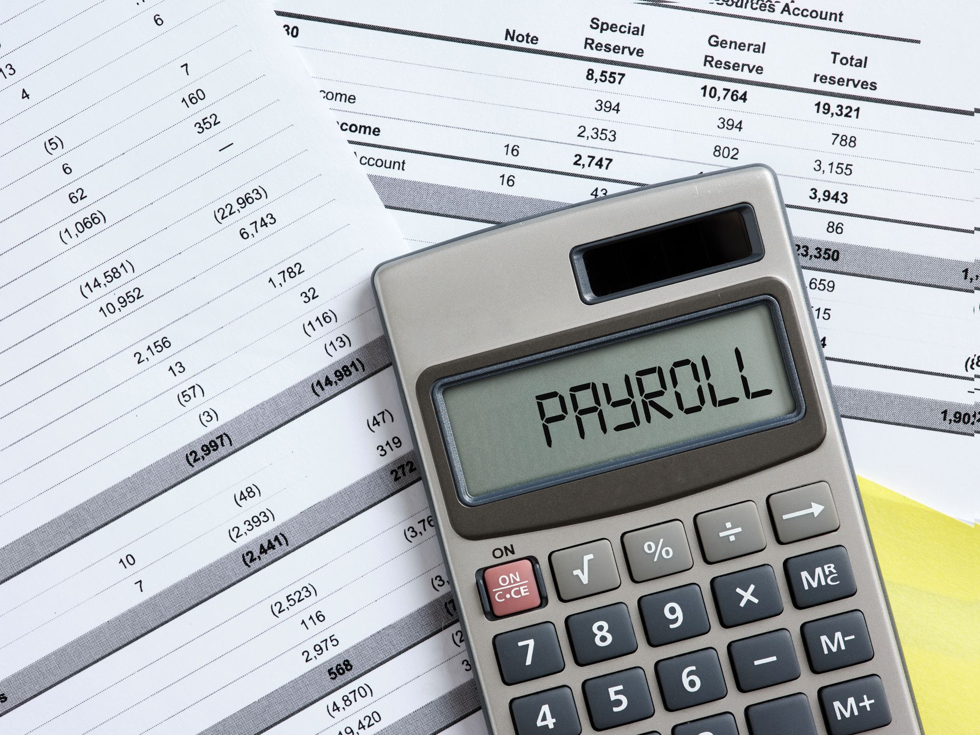 Calculator on payroll spreadsheets with “PAYROLL” displayed on the screen.