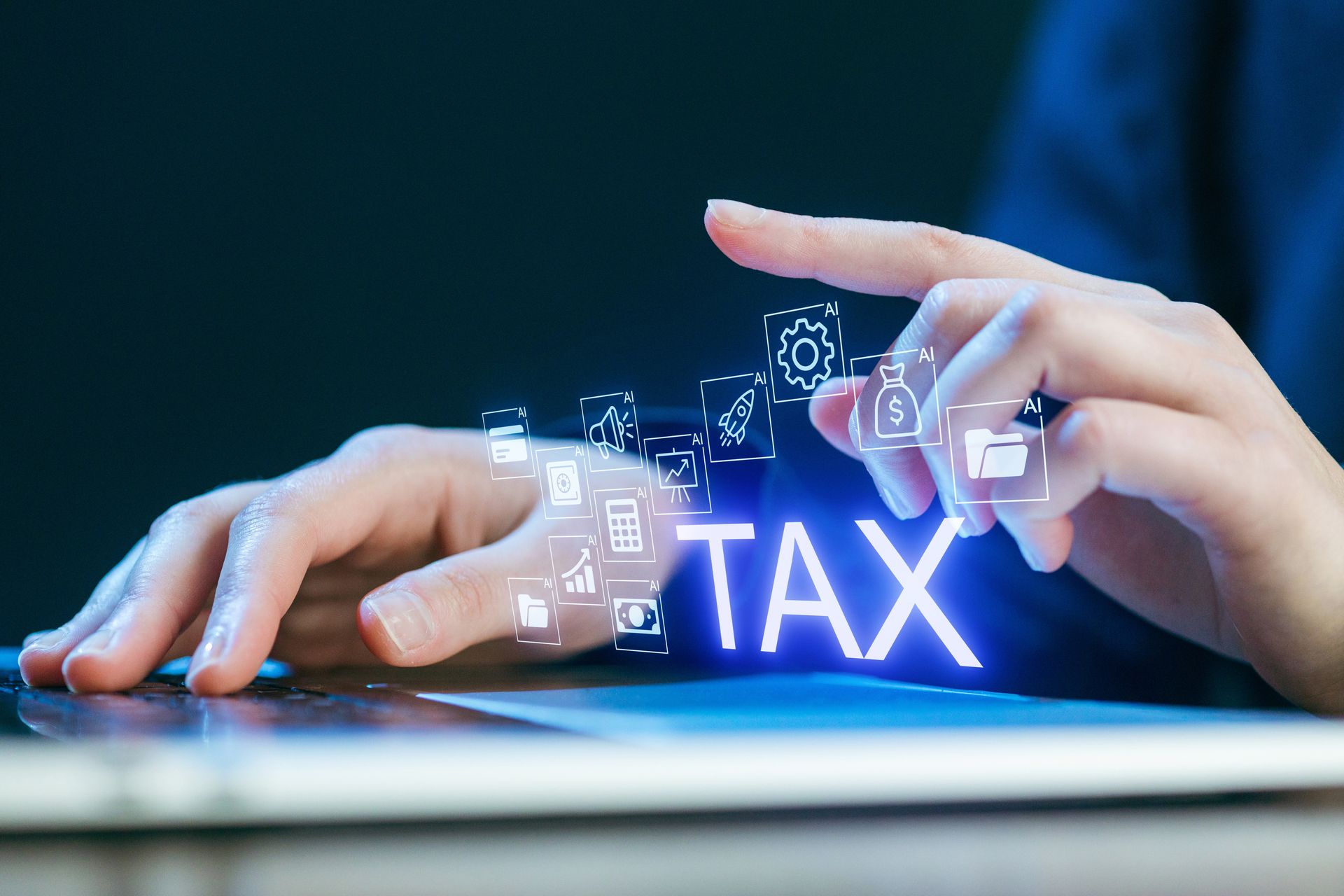 Hands typing on a keyboard with glowing “TAX” text and digital finance icons above it