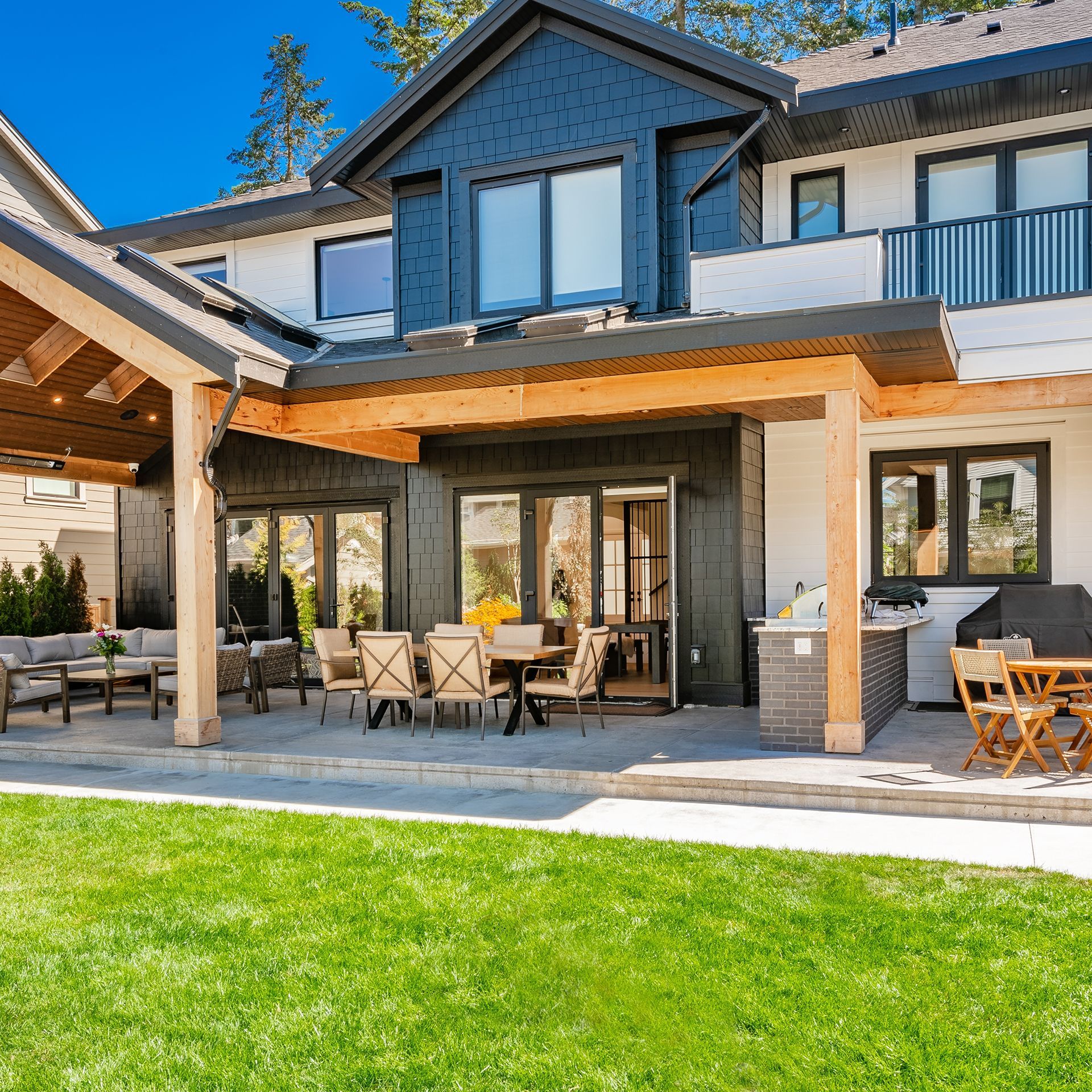 A large house with a covered patio with tables and chairs