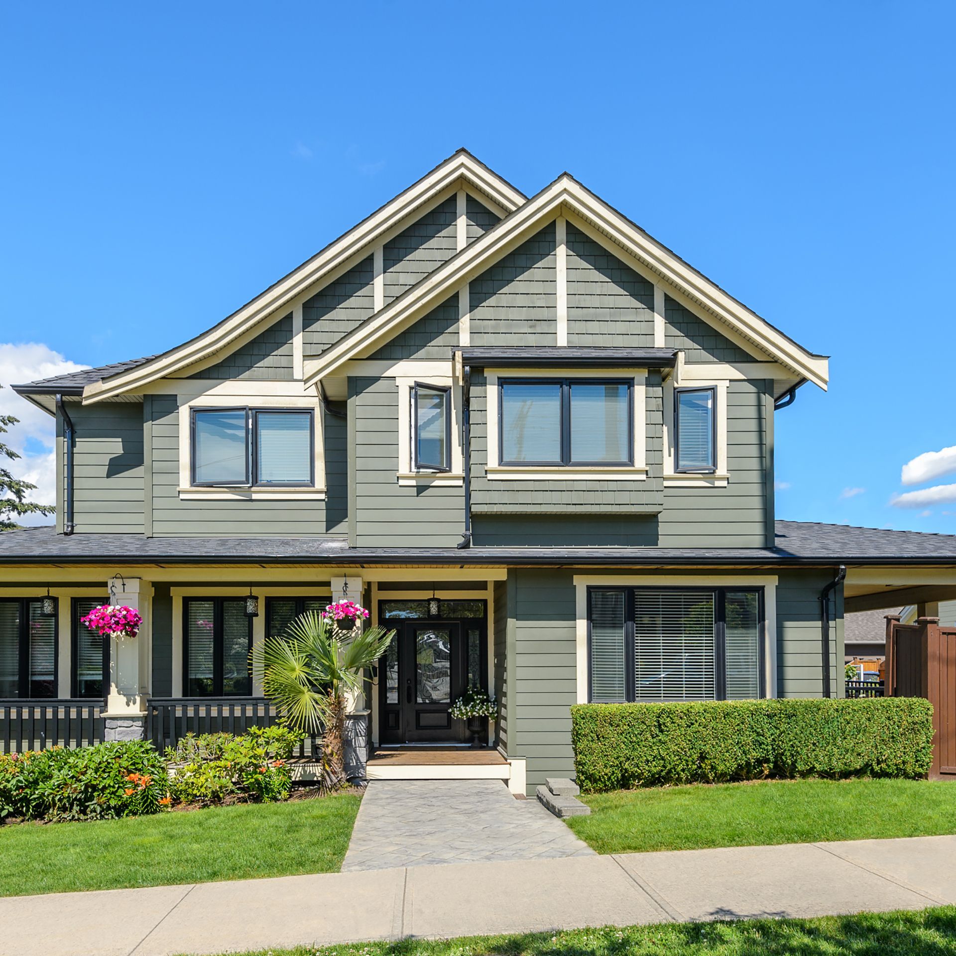 A large house with a lot of windows and flowers in front of it