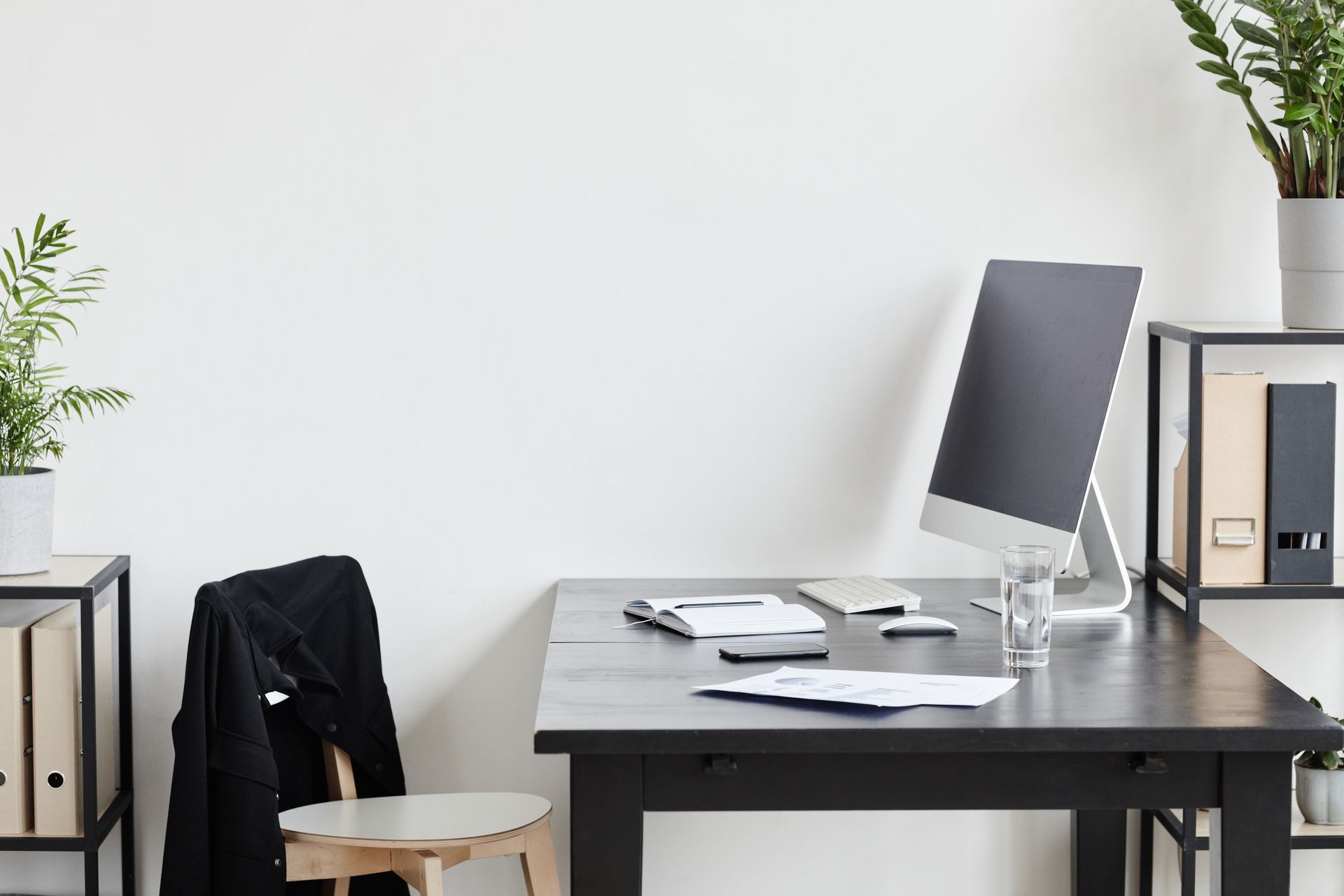 office workspace featuring a black desk with a computer monitor
