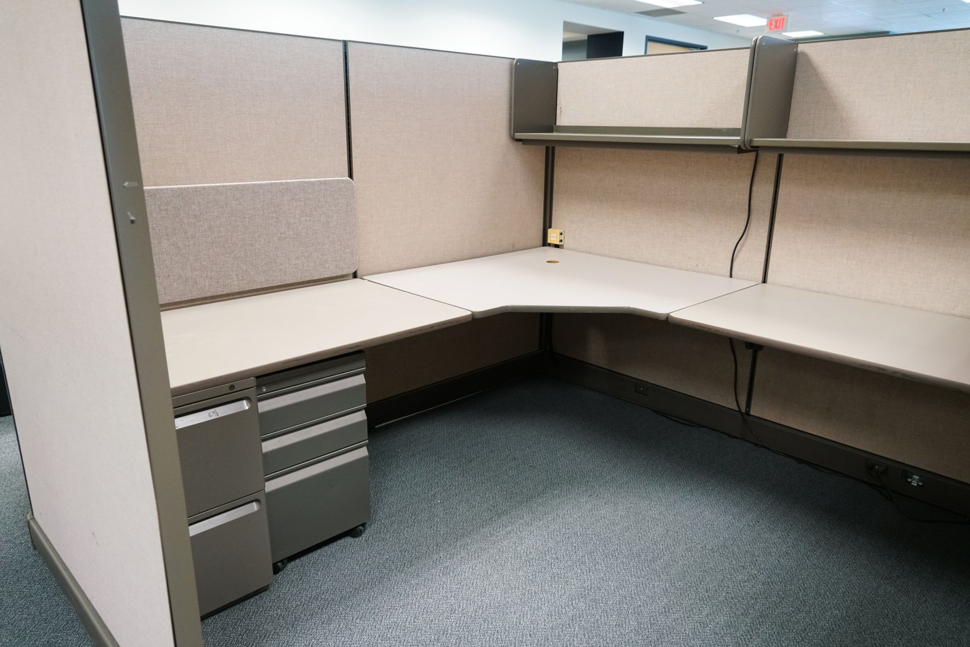 Used office cubicle with beige fabric panels, an L-shaped desk Used office cubicle with beige fabric panels, an L-shaped desk