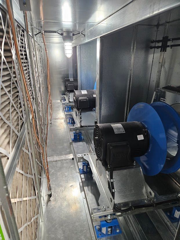 À l'intérieur d'un système de refroidissement industriel ; plusieurs moteurs avec ventilateurs bleus.