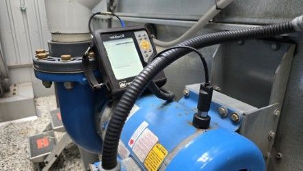 Pompe bleue avec dispositif de surveillance intégré ; environnement industriel.
