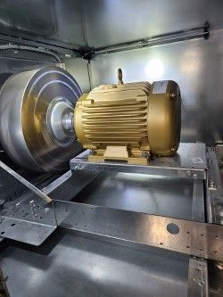 Moteur électrique en or sur un banc d'essai à l'intérieur d'une chambre métallique fermée.