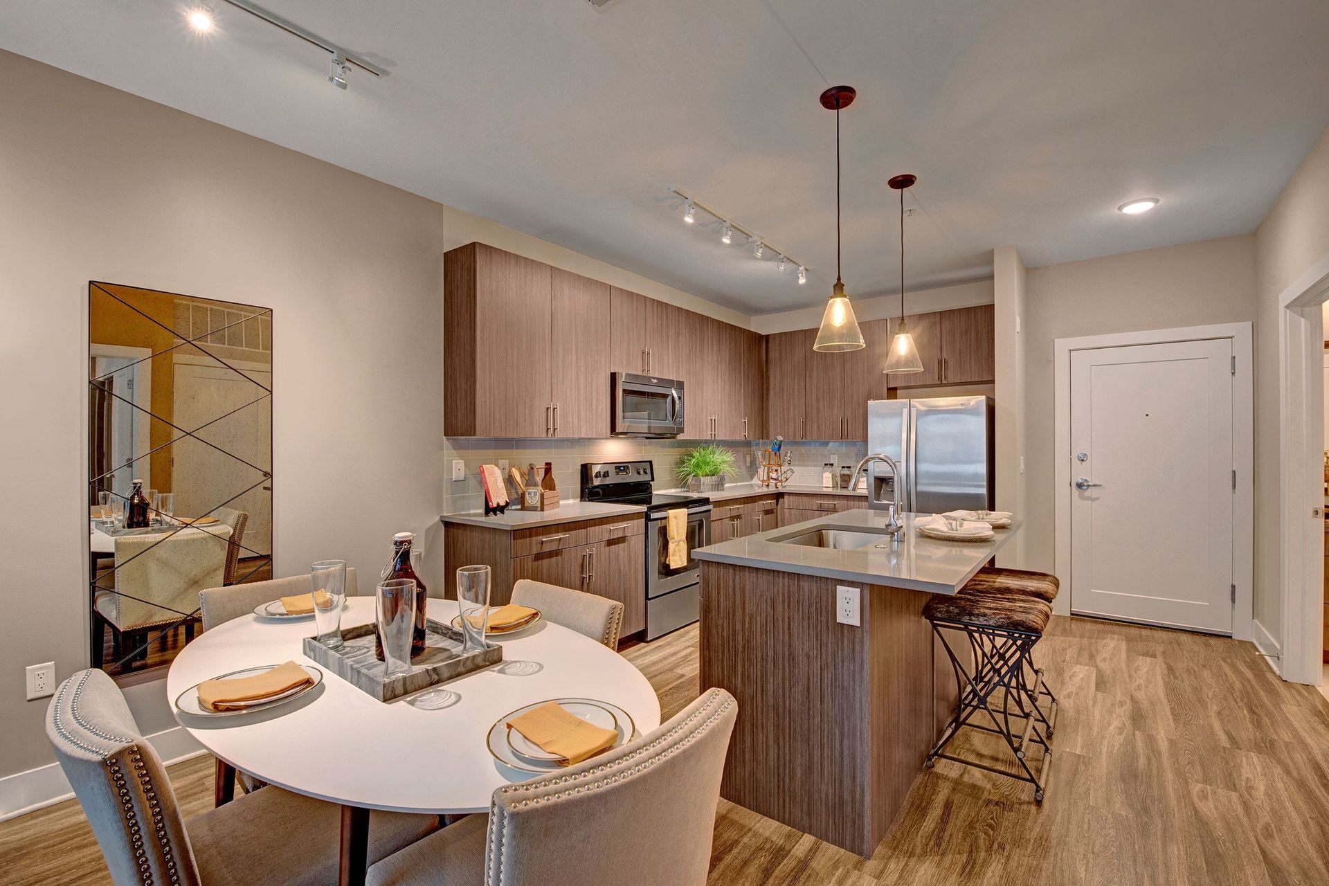 Modern kitchen and dining area with a round table, cabinets, and stainless steel appliances.