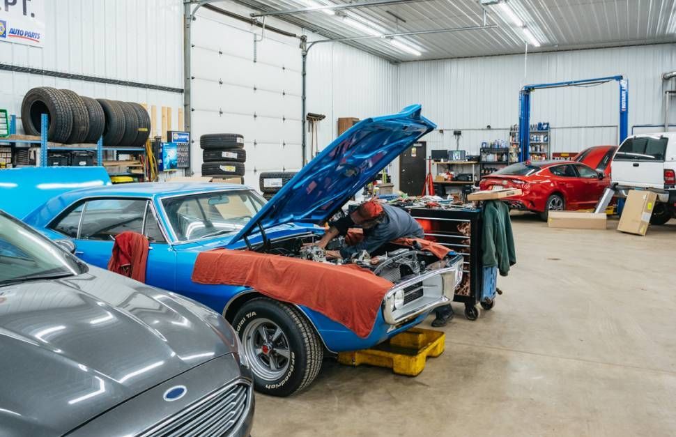 Mechanic working on a classic blue car 