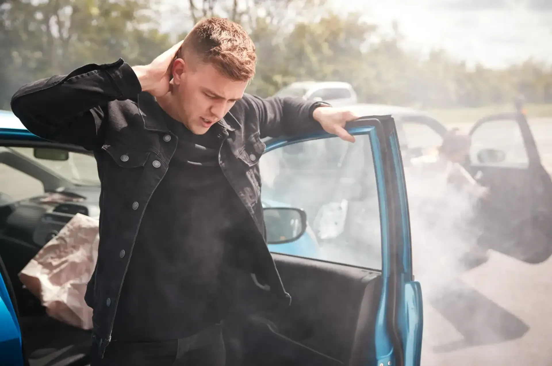 Man standing by an open blue car door, leaning out in a smoky street scene