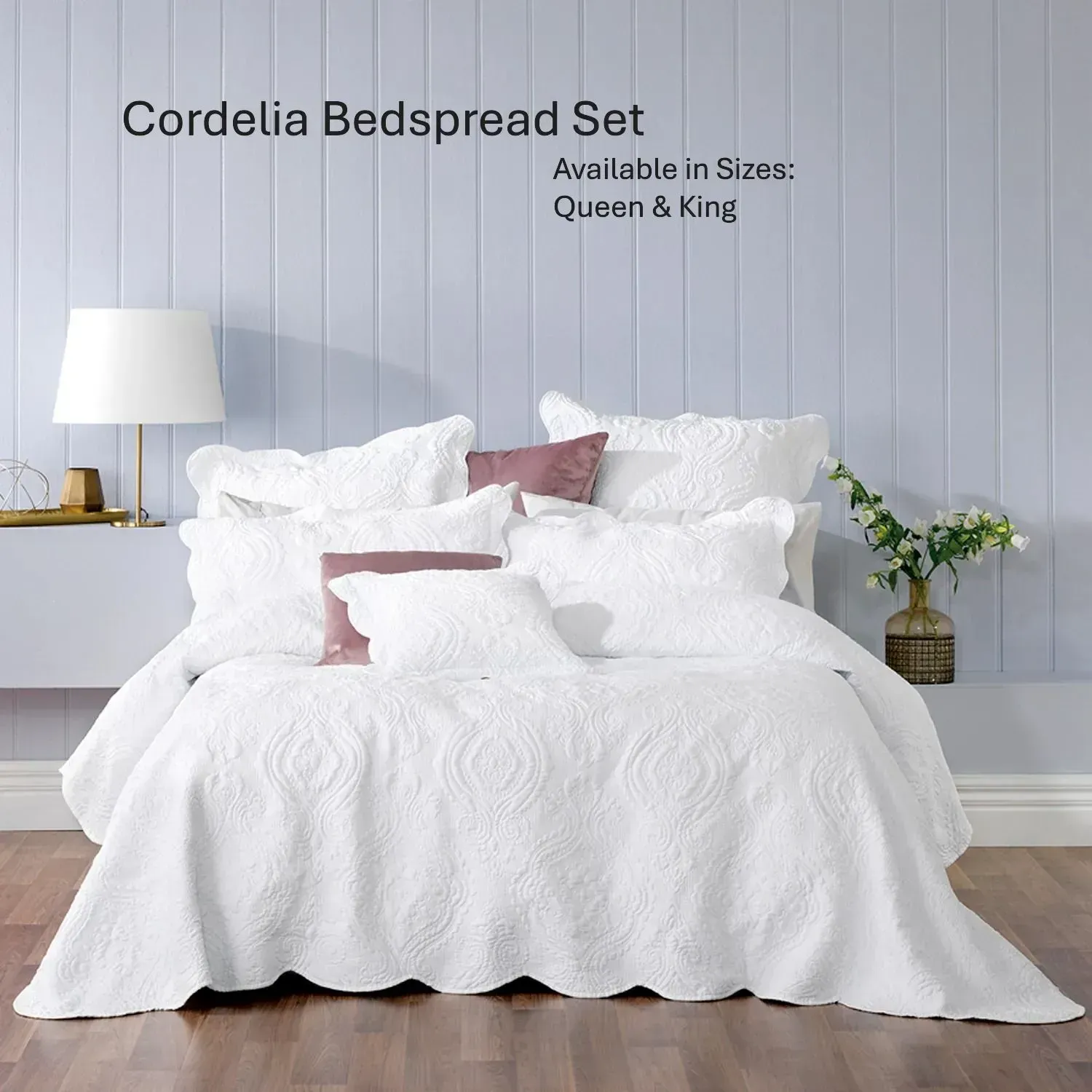 White quilted bedspread set on a bed in a gray bedroom, with lamps, pillows, and small plants.
