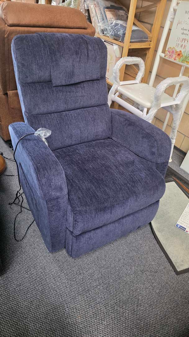 Blue recliner chair on a carpeted floor in a furniture store aisle