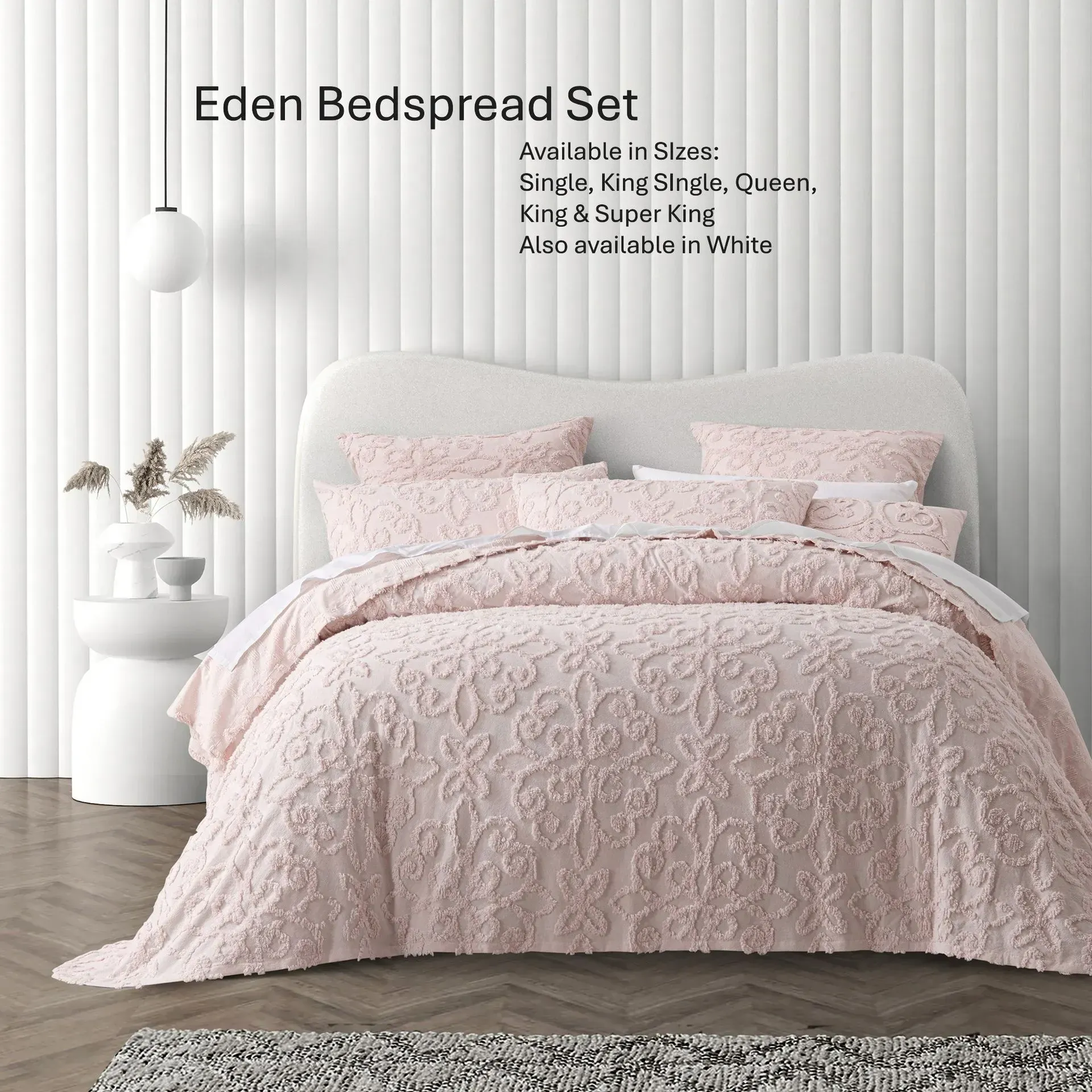 Pink quilted bedspread set on a bed in a bright bedroom with white vertical striped walls.