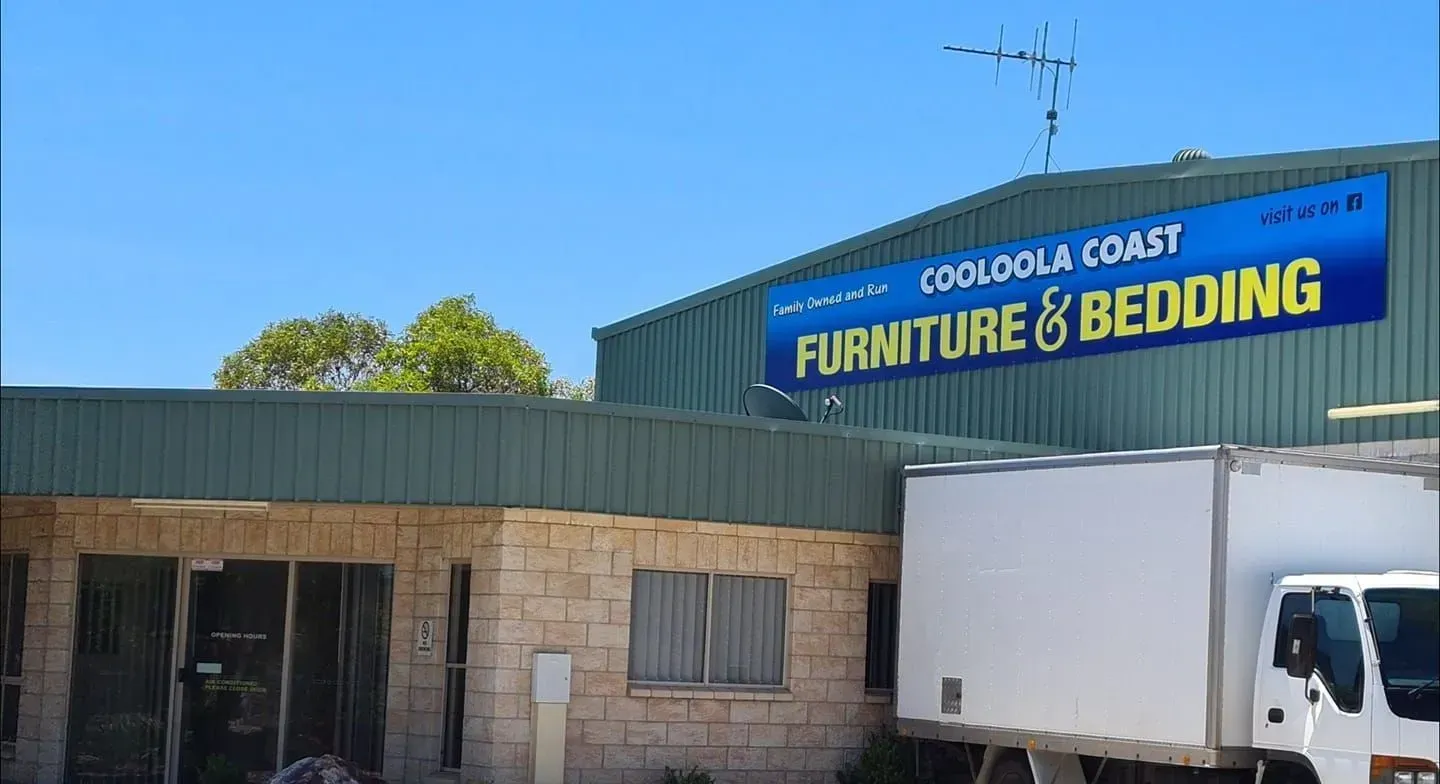 Furniture and Bedding storefront with blue sign and white delivery truck outside