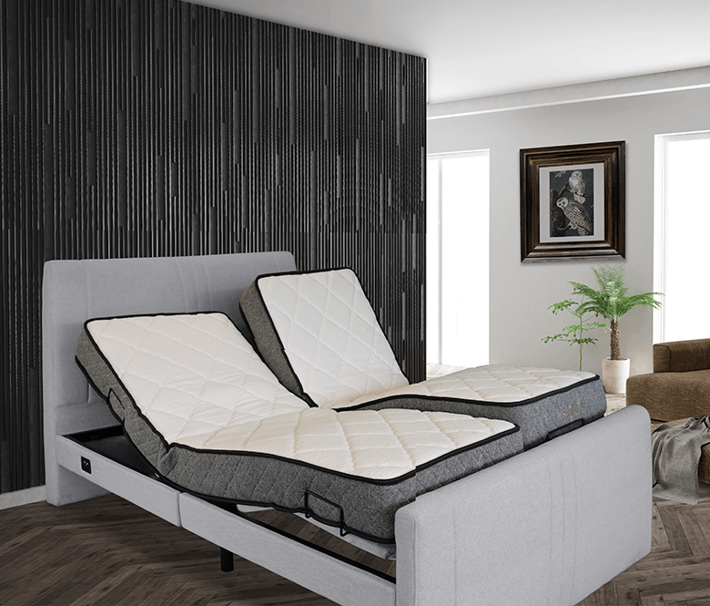 Modern gray bed with adjustable bedding in a minimalist bedroom with dark accent wall.