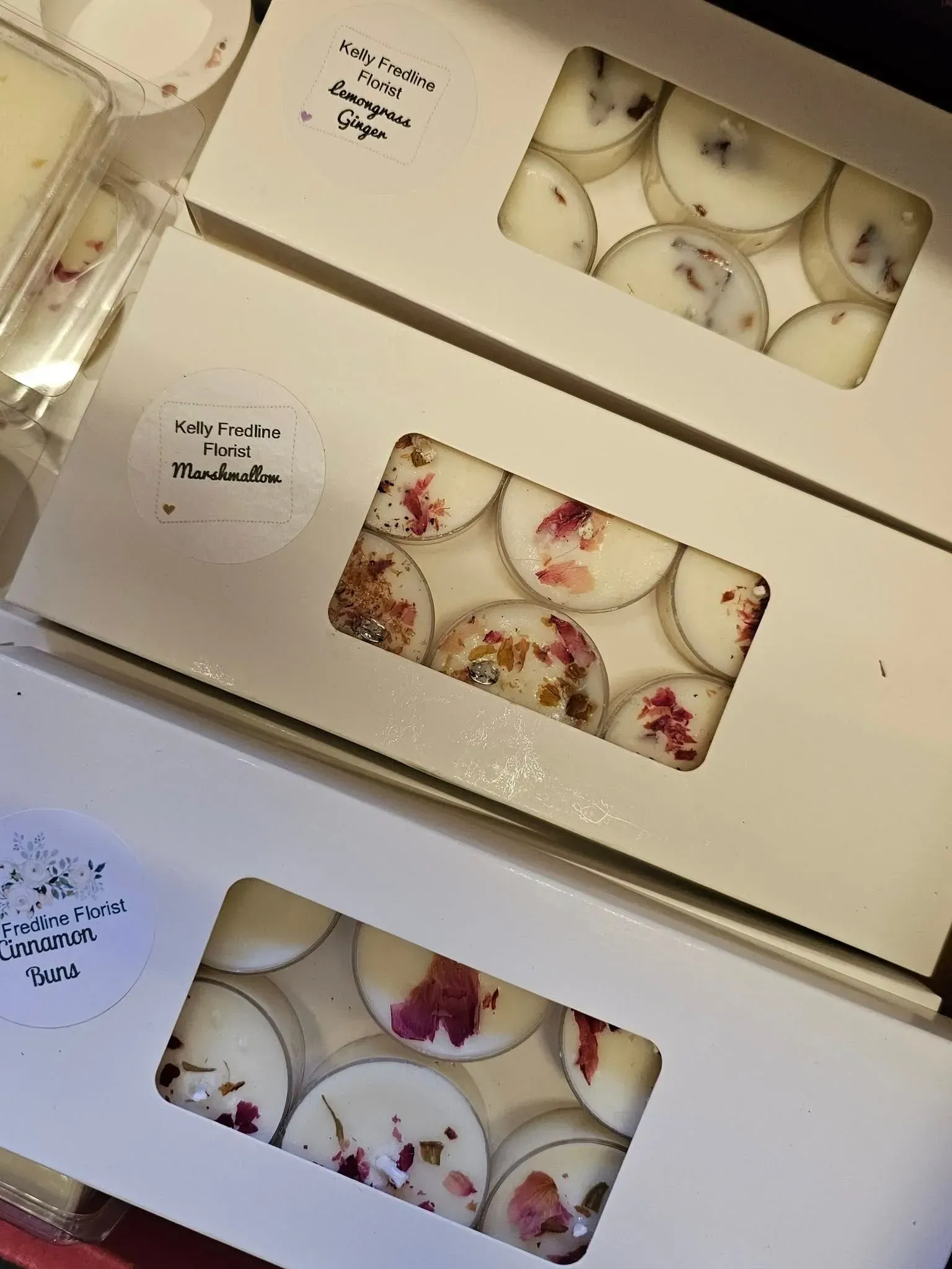 Decorative dessert boxes with window cutouts showing white sweets topped with flowers and dried fruit
