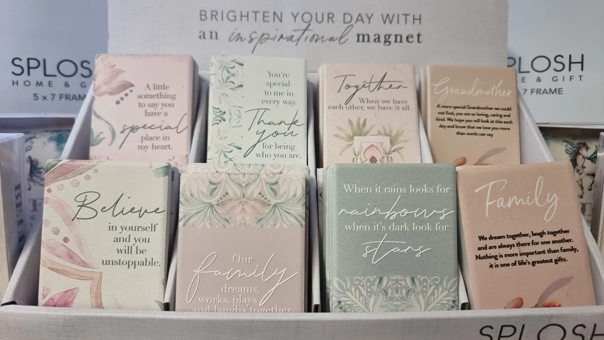 Greeting cards and notebooks on a shelf with pastel floral designs and inspirational messages.