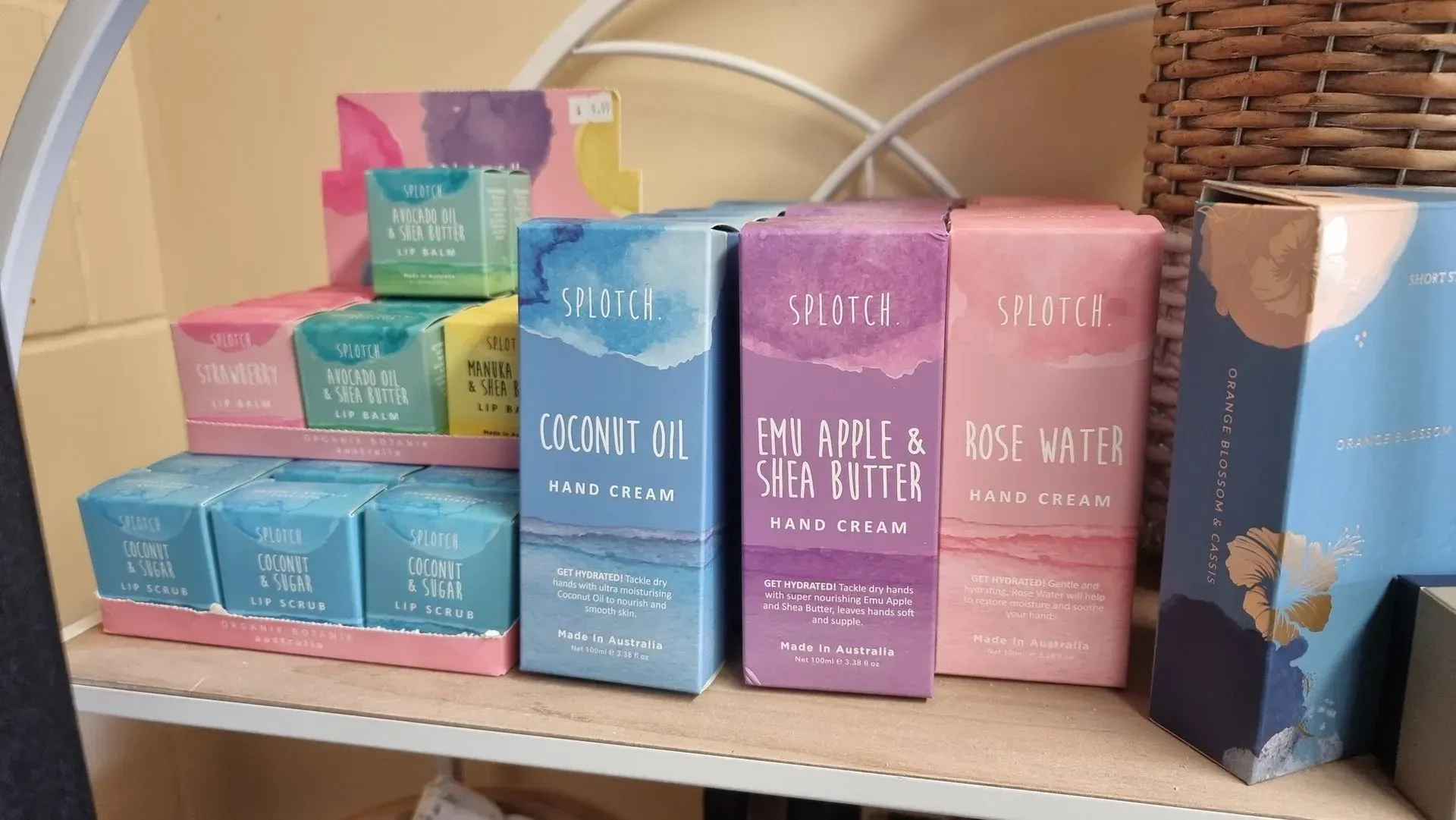 Colorful tea boxes arranged on a shelf beside a blue floral tin