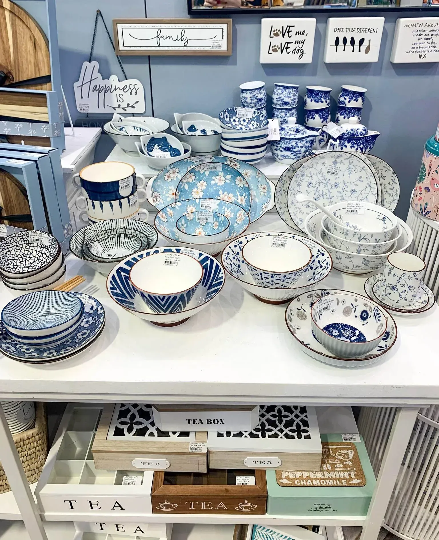 Blue-and-white patterned ceramic bowls and dishes displayed on white shelves in a shop.