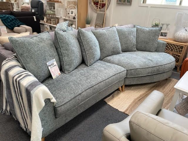 Gray sectional sofa with striped armrest cover in a furniture showroom