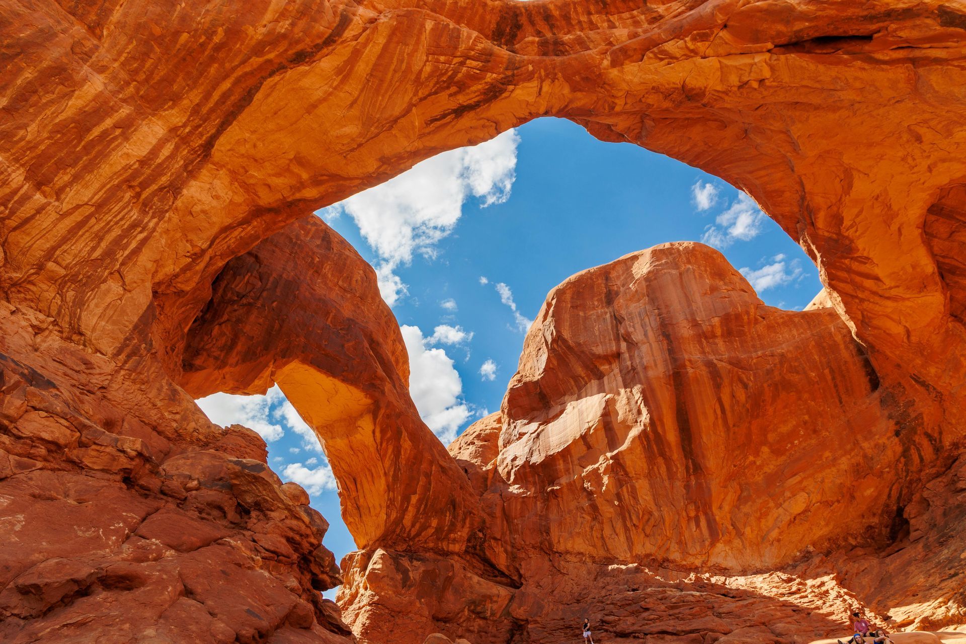 Red rock formations with openings against a blue sky, Double Arch in Arches National Park.