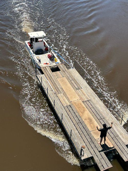 Commercial work boat operating beside a pontoon barge on a marine project