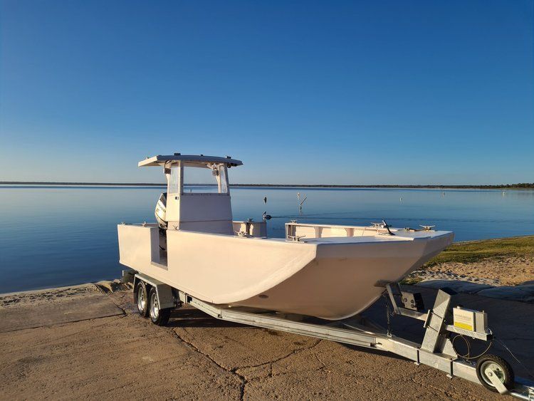a boat is on a trailer near a body of water