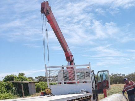 a red crane is attached to the back of a tow truck .